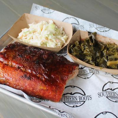 Glazed ribs with collard greens and coleslaw on a tray