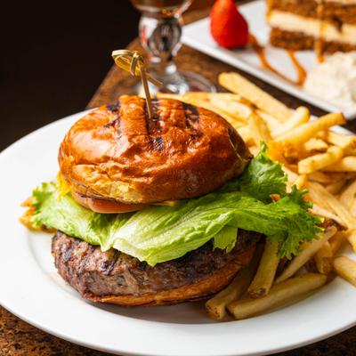 Burger topped with lettuce and served with fries.