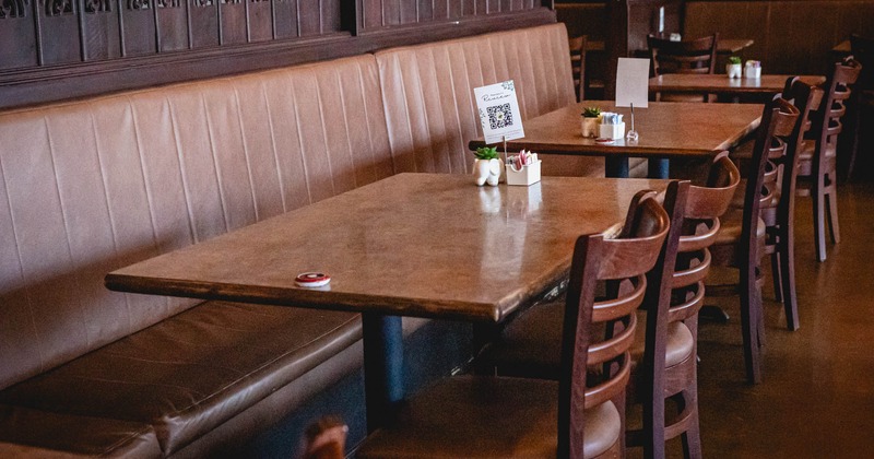 Interior, tables with banquette seating and chairs ready for guests