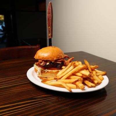 Burger with bacon and bbq sauce served with fries.