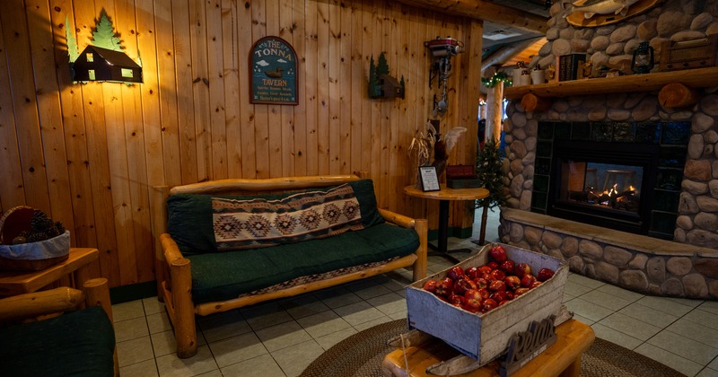 Cozy and warm cabin-style interior space with a wooden sofa and fireplace