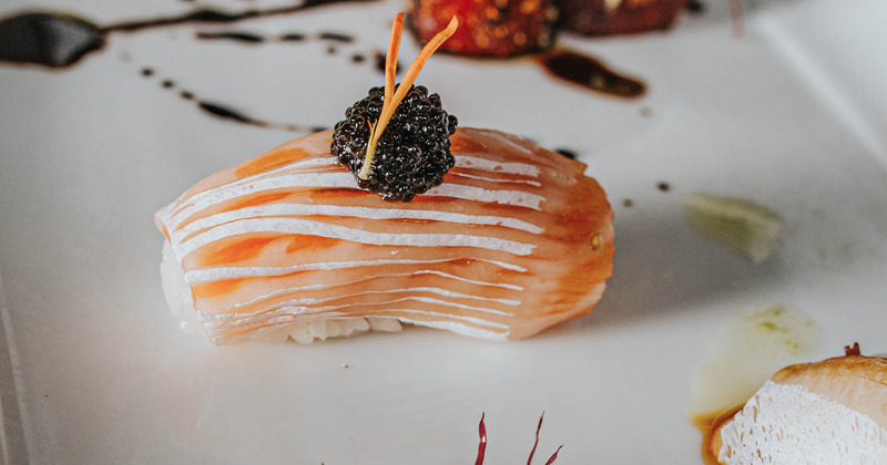 Sashimi topped with a blackberry