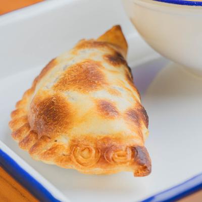 Baked empanada on a white plate.