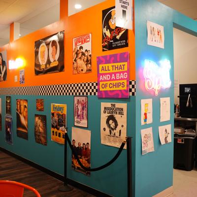 Wall adorned with the 90s movies and TV posters.