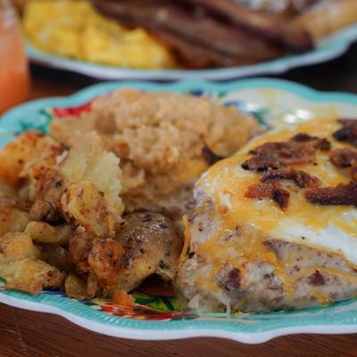 Grits breakfast with eggs, bacon, and smashed potatoes.
