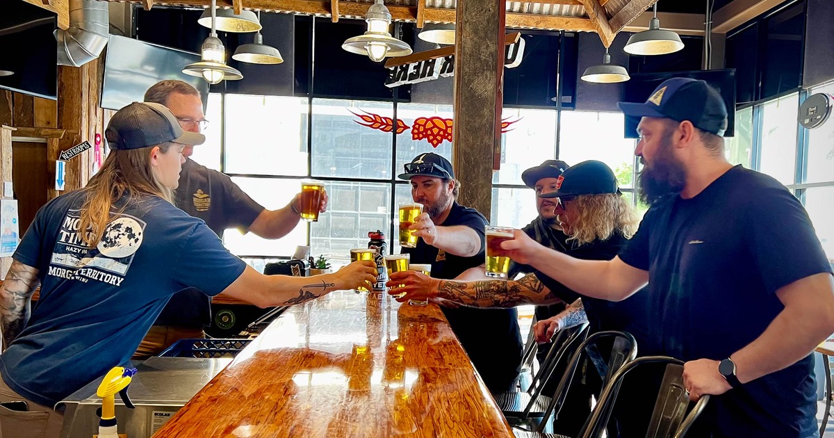 People toasting with their drinks at the bar