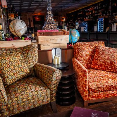 Patterned lounge chairs inside a cozy wine bar.