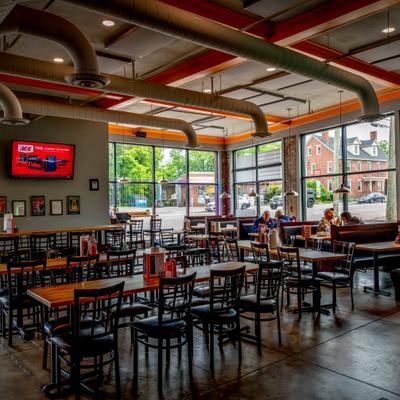 Modern restaurant interior with industrial design, dining area with a few patrons.