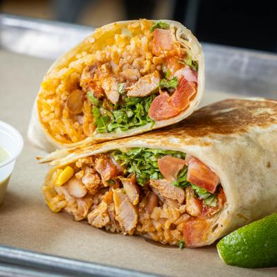 Chicken tinga burrito halves filled with rice and vegetables.