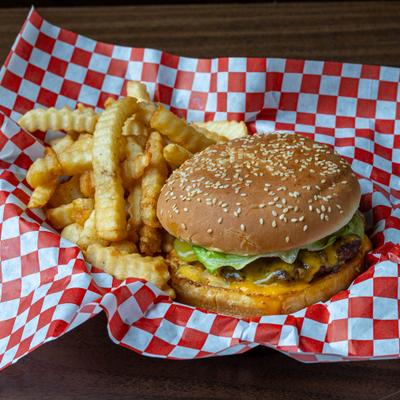Beef Burger with cheese, lettuce, pickles and a side of crinkle-cut fries.