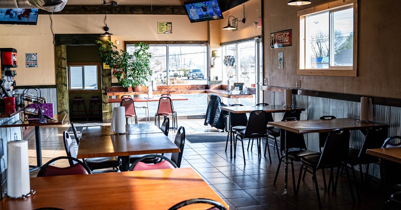 Interior, tables and chairs, restaurant entrance, large shop windows, TV sets in the corners