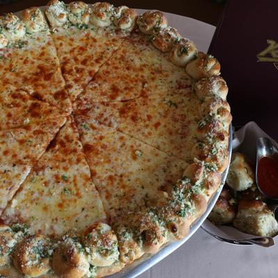 Sweet and Sour Chili Chicken Pizza, with spinach, artichoke hearts, and garlic knot crust.