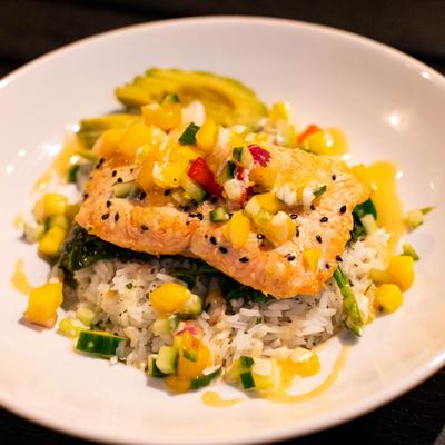 Sesame crusted salmon on a bed of rice, with spinach, and mango cucumber salad.