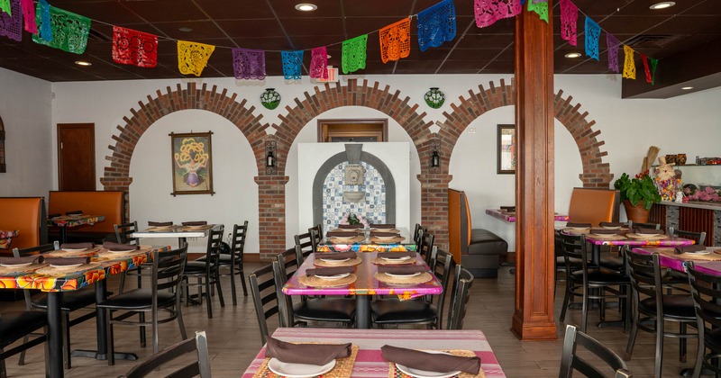 Interior of a vibrant restaurant with colorful papel picado hanging from the ceiling