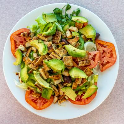 Garden Salad with grilled chicken and avocado, top view.
