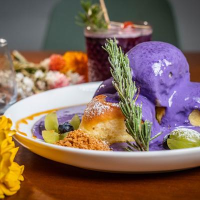 Ube butter toast with a purple cocktail in the background.