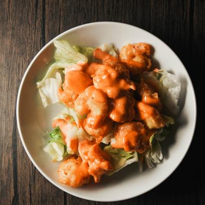 A plate of fried chicken pieces covered in a creamy sauce.