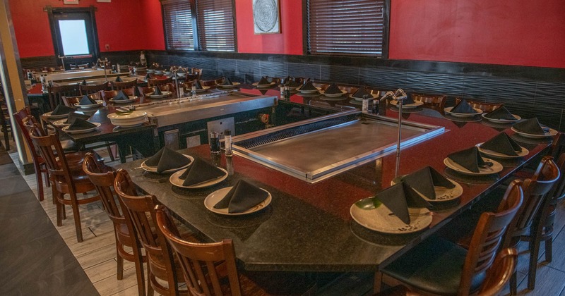 Interior, hibachi tables with wooden chairs, ready for guests, tile flooring