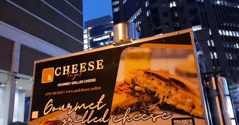 & Cheese To-Go trailer parked at night in a city setting