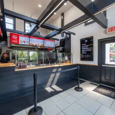 Interior with dark wood-paneled ordering counter and digital menu screens.