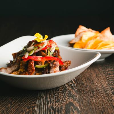 Ceviche de Chicharron topped with with onions and peppers, served with chips.