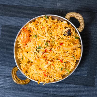 Vegetable biryani served in a bowl with handles.