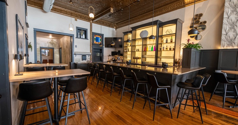 Tables with bar stools and a bar on the right