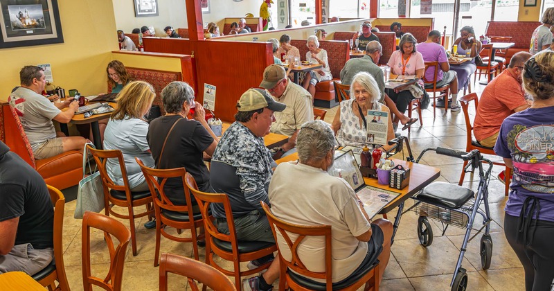 Dining area with customers sitting at tables and booths