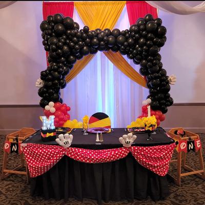 Mickey Mouse themed birthday table with balloons.