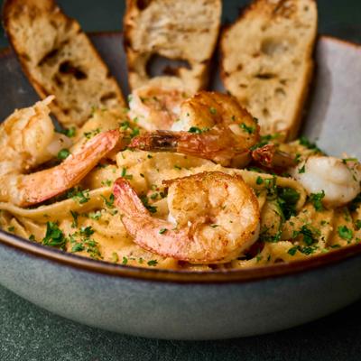 Blackened shrimp alfredo pasta with toasted bread.