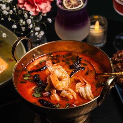 Spicy Thai shrimp soup served with a cocktail.
