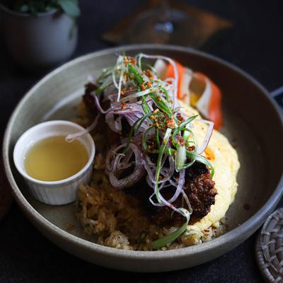 Pork sausage topped with onion slaw served over garlic fried rice and scrambled eggs.