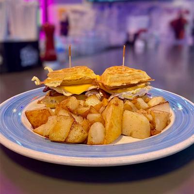 Waffle breakfast sandwich with home fries.