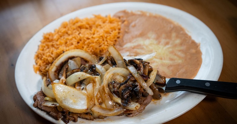 Ribeye steak, with grilled onions, mushrooms, cheese, rice, and ebans