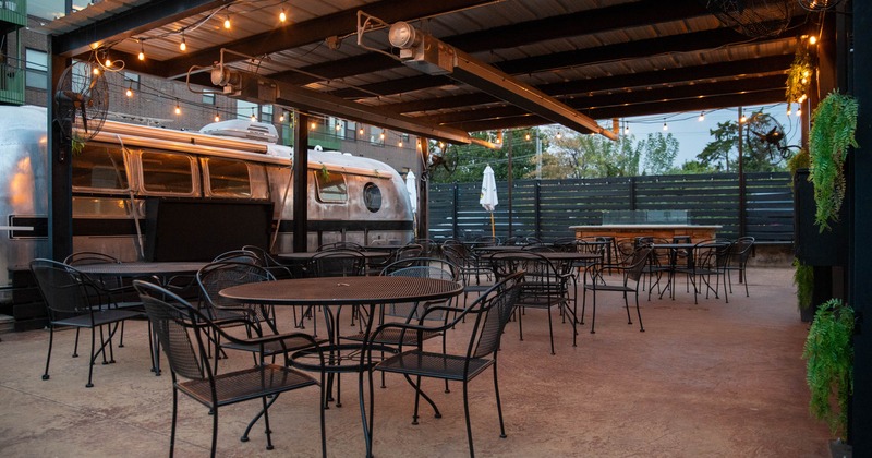 Outdoor dining area with string lights, metal tables and chairs
