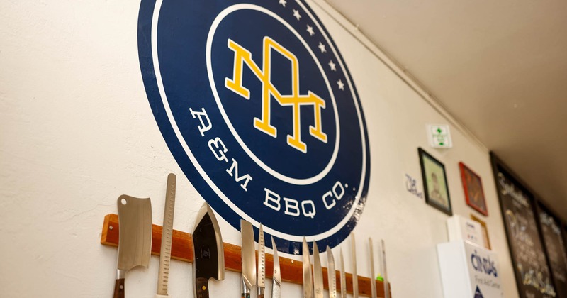 The restaurant's logo and a knife board on the wall