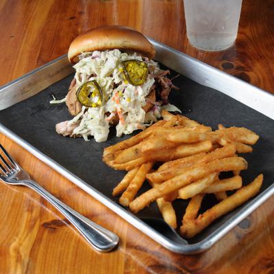 Pulled pork sandwich served with fries.
