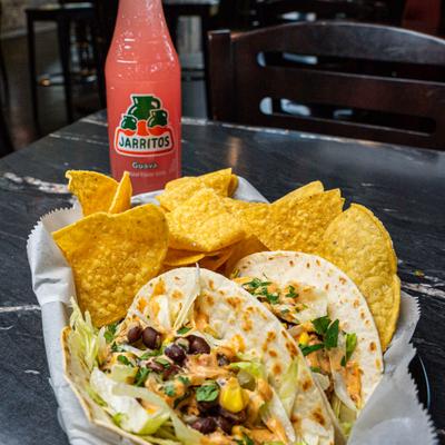 Pulled Pork Tacos with tortilla chips and a bottle of Mexican flavor soda.