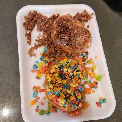 Churros topped with colorful Fruity Pebbles and chocolate-flavored cereal bits.