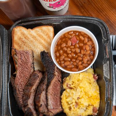 Sliced prime rib, potato salad, beans, and toast.