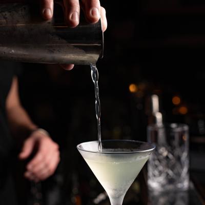 Cocktail being strainted from the shaker into a martini glass.