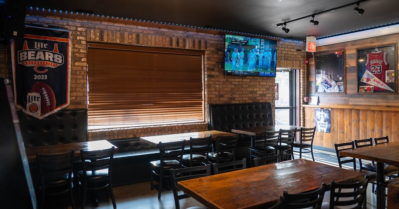 Interior of a sports bar with brick walls, sports memorabilia, and wooden furniture