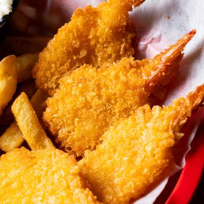 breaded butterflied shrimp served in a basket with fries and coleslaw.