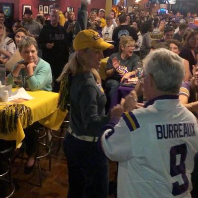 Older guy in the front, crowd in the back, yellow and purple motifs