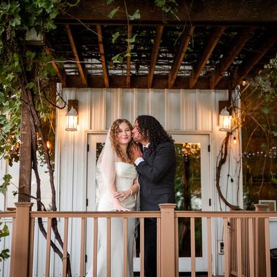 Wedding couple standing outside the Barrel Room under the vines at Next Chapter Winery.