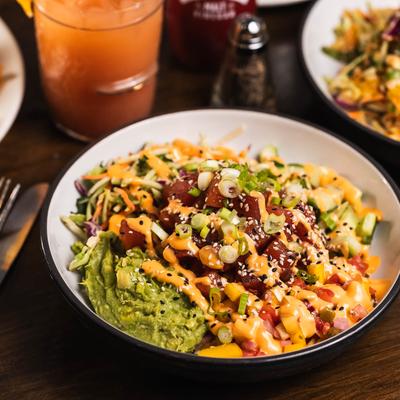 Tuna poke bowl served with a cocktail.