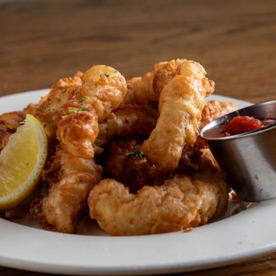 Fried calamari served with marinara sauce and a lemon wedge.