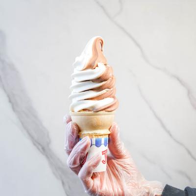 A cone of ice cream in hand.