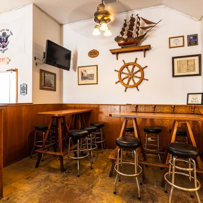 Interior with high-top tables, matching stools and nautical decorations.