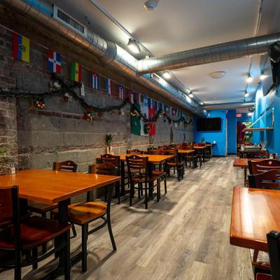 Dining room with exposed brick walls and a string of international flags.